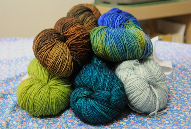 Clockwise from top left: Dragonfly yarns Dragon Sock in Mushroom Hunting B-Side and Djinni Sock in Admiral Benbow; Tosh Sock in Celadon and Cousteau; and Malabrigo Sock in Lettuce.